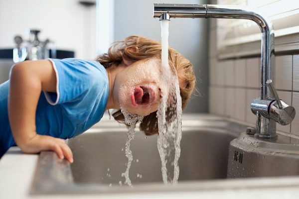 Ребёнок пьёт воду из-под крана