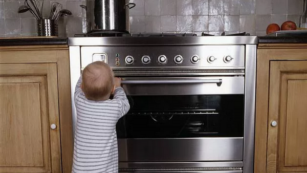 Малыш у плиты с кастрюлей