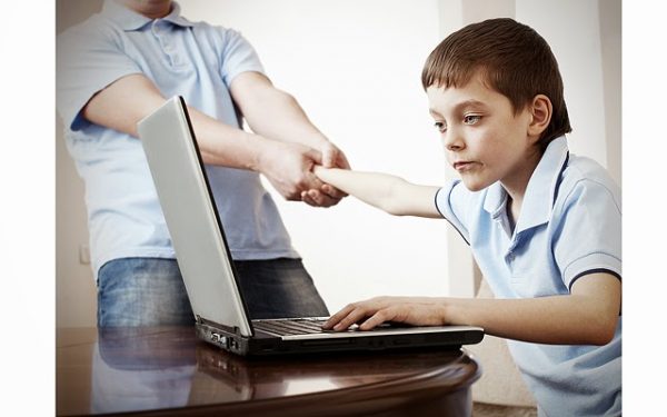 Папа пытается оттянуть сына от компьютера