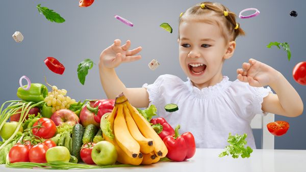 Девочка радуется овошам и фруктам