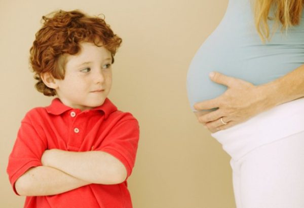 Мальчик смотрит на беременную маму