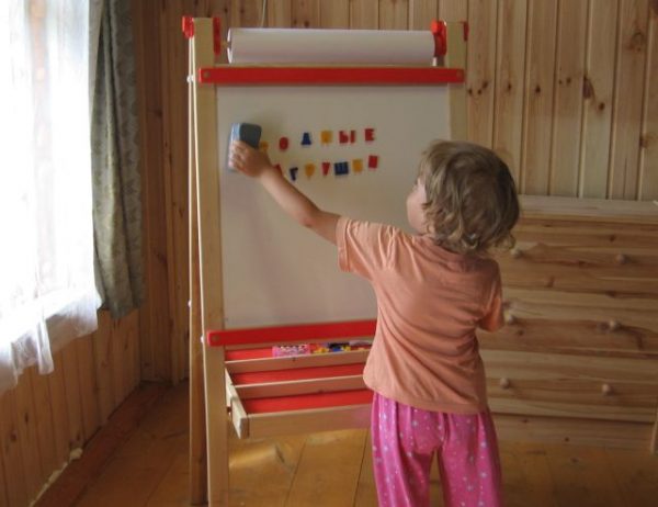 Ребенок учит буквы с помощью мольберта