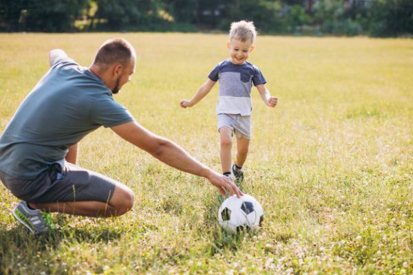 Папа с сыном играют в футбол