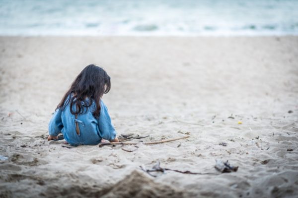 Одинокая девочка на пляже