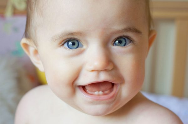 Красивый малыш улыбается в два зуба