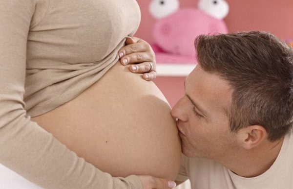 Муж целует живот беременной жены