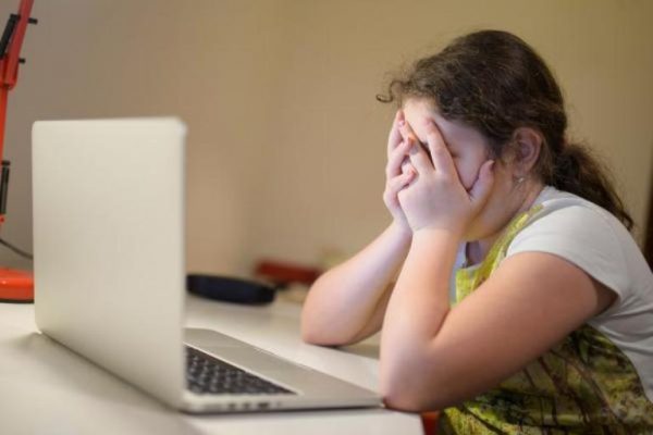 Девочка плачет перед ноутбуком
